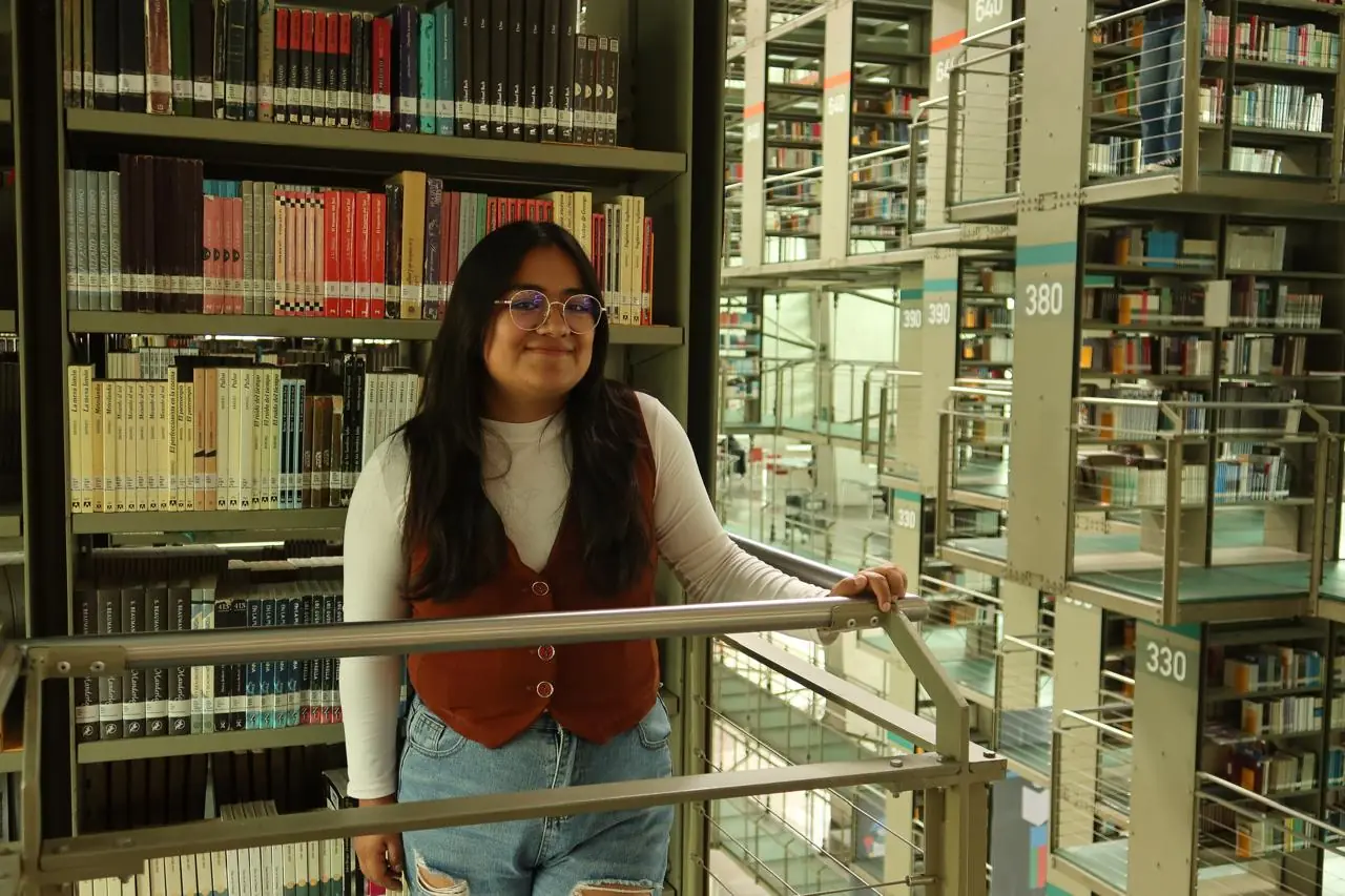 Ximena Pastor en una biblioteca entre libreros